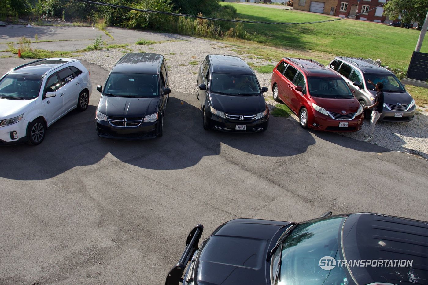 STL Transportation minivans staged at the company lot