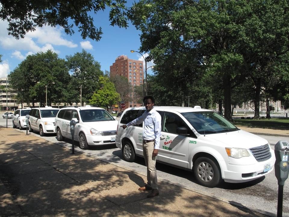 STL Transportation founder standing with the taxi fleet in St. Louis